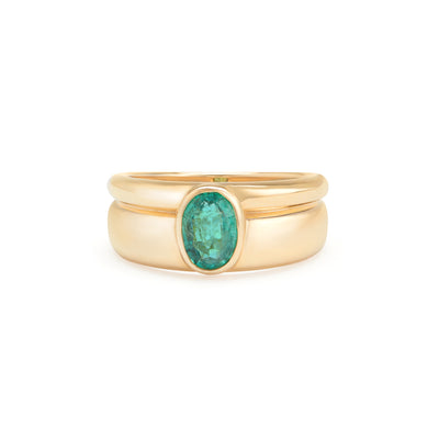 yellow gold ring with emerald center stone on white background