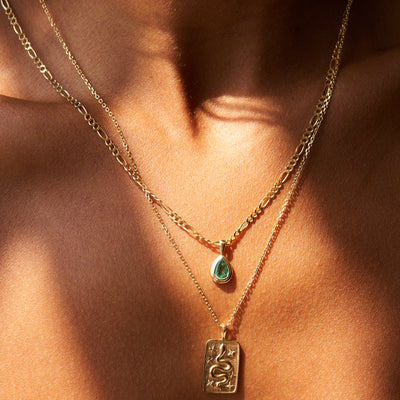 Snake pendent yellow gold on cable chain and emerald pear shaped pendent yellow gold on Figaro chain on model