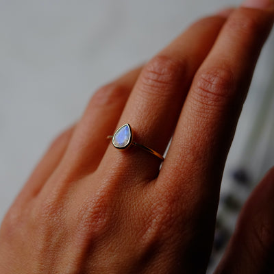 Hand model wearing a pear cut moonstone ring.