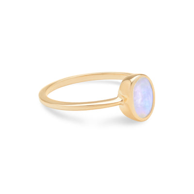 14 Karat Yellow Gold Ring with Oval Shaped Moonstone Stone Against White Background Turned to Side